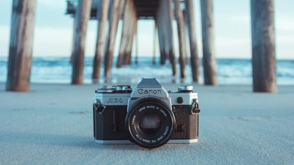 A camera on the beach, under a peer